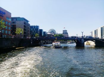 Bridge over river against sky in city