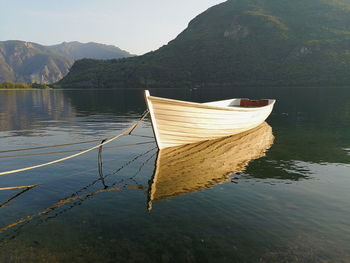 Boat moored on lake against mountains