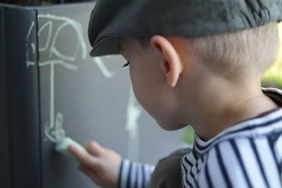 Boy drawing with chalk in classroom