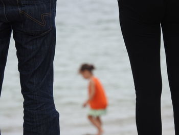 Rear view of couple standing at beach