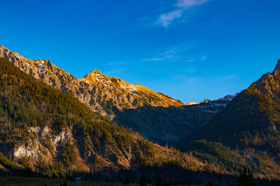 Scenic view of mountains against blue sky