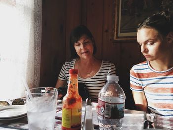 Mother and daughter sitting at table in restaurant