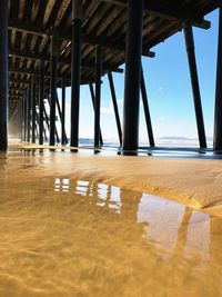 Low angle view of pier over sea against sky