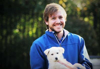 Portrait of smiling young man with puppy