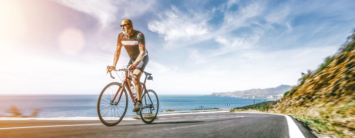 Bicycle on road by sea against sky