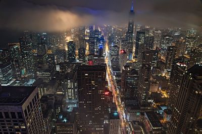 Illuminated cityscape against sky at night