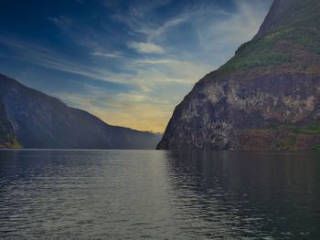 Scenic view of lake by mountains against sky