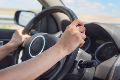 Cropped hands of person driving car