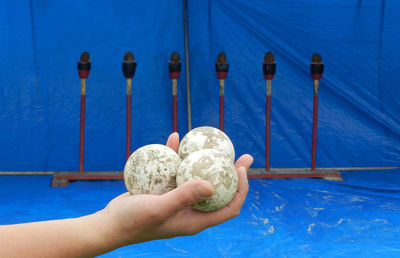 Close-up of hand holding blue paint