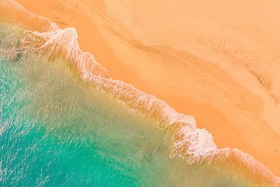 Aerial view of atlantic ocean coast with crystal clear turquoise water, waves rolling into the shore