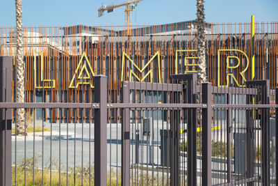 Text on metal fence against clear sky