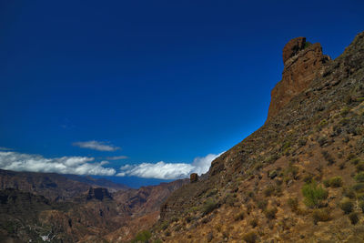 Scenic view of mountains against blue sky