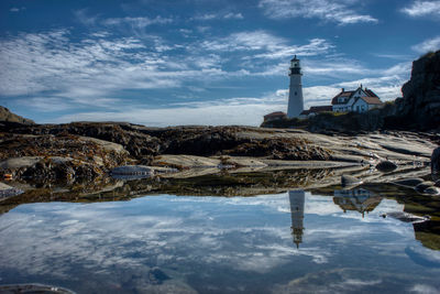 High angle view of lighthouse by buildings against sky