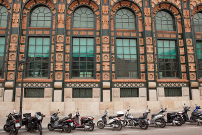 Motorcycles and motor scooters parked by building