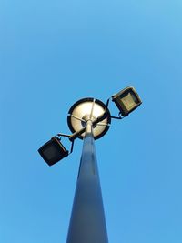 Low angle view of illuminated street light against clear blue sky