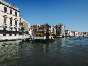 Canal against buildings in city on sunny day