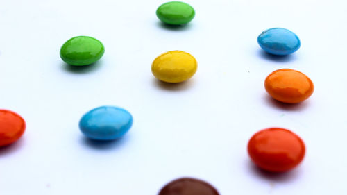 High angle view of multi colored candies against white background