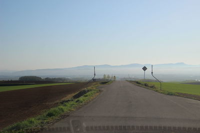 Empty road on field against clear sky