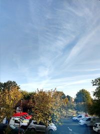 Cars on road against sky during autumn