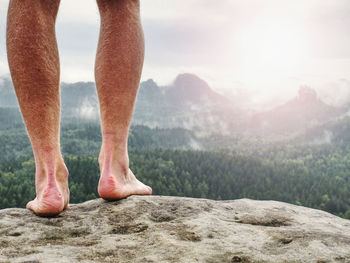 Low section of man standing on rock