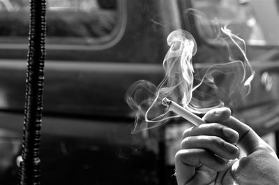 Close-up of hand holding cigarette