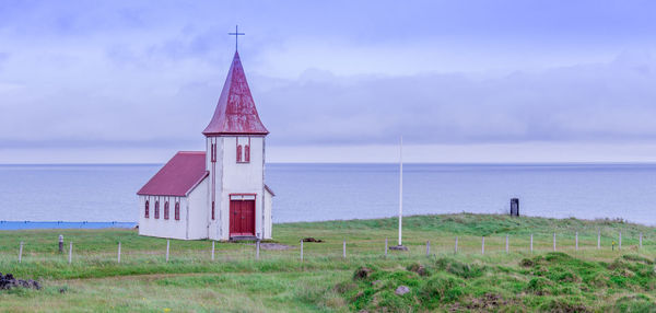 Traditional building on shore against sky