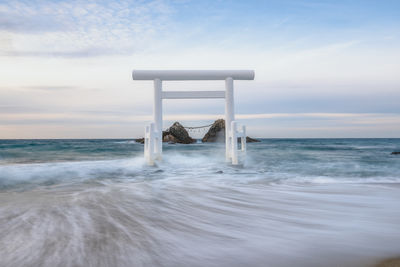 Lifeguard hut in sea against sky