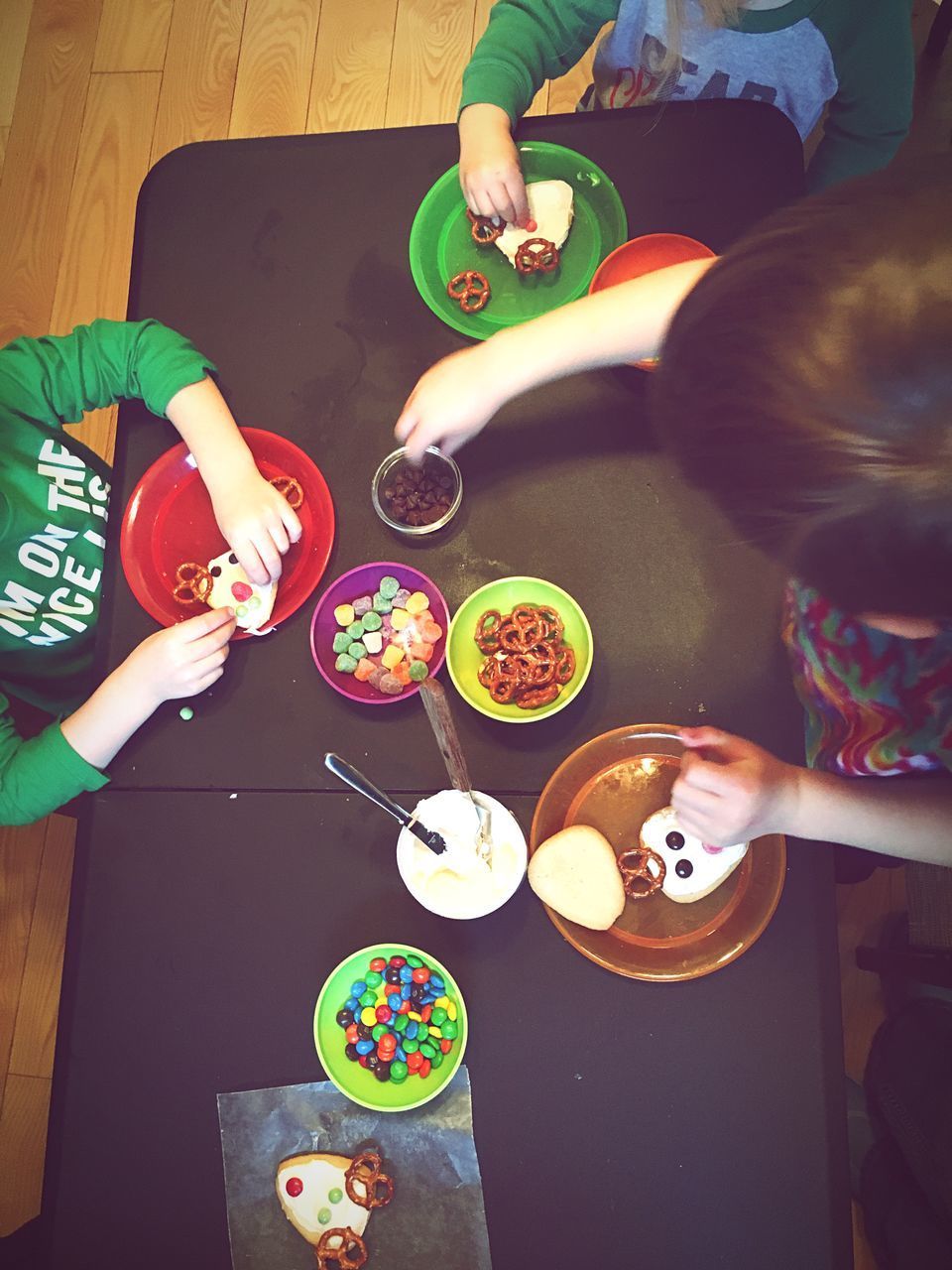 HIGH ANGLE VIEW OF PEOPLE HOLDING FOOD ON TABLE