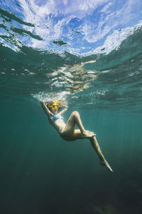 Carefree young woman swimming undersea