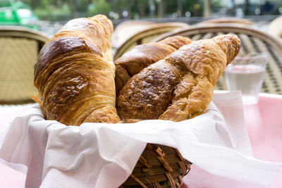 Close-up of croissants in wax paper at table