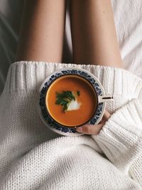 Midsection of woman with soup at home