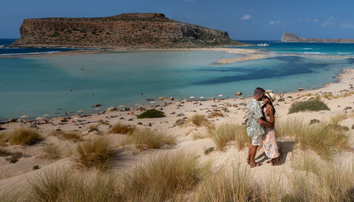 People at beach against sky
