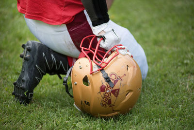 Low section of person holding ball on field