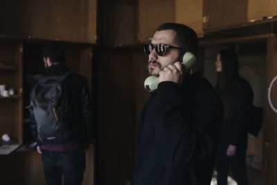 Man talking on telephone with friends at home