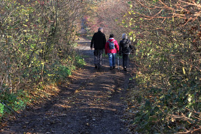 Rear view of people walking on footpath