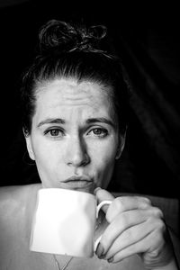 Close-up portrait of young man drinking coffee at home