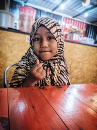 Portrait of cute girl sitting in restaurant