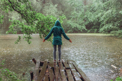 Full length of boy standing on riverbank in forest