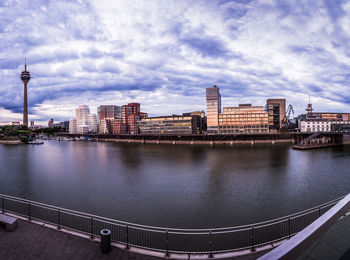 River in city against cloudy sky