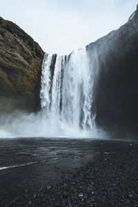 Scenic view of waterfall against sky