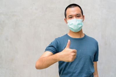 Portrait of man standing against wall