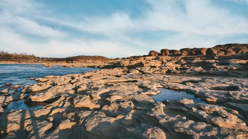 Rock formations by sea against sky