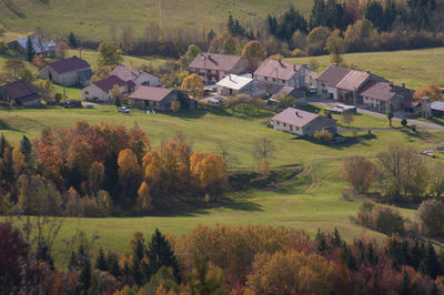 Scenic view of agricultural field by houses and trees