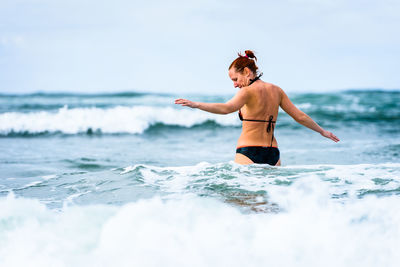 Full length of woman on beach against sky