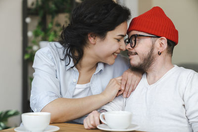 Smiling affectionate couple rubbing noses at home