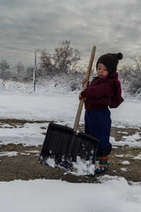 Child plays with snow shovel