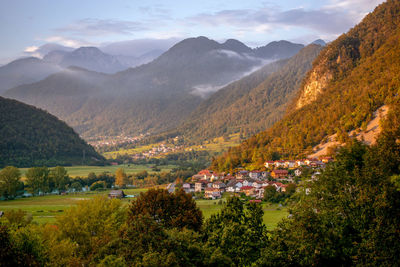 Panoramic view of julian alps at sunset with small towns in horizont