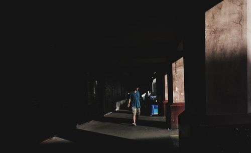 Rear view of people walking in corridor of building