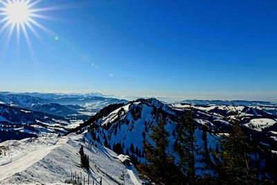 Scenic view of snowcapped mountains against blue sky