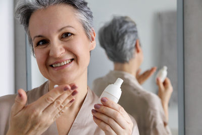 Close-up of young woman applying make-up to daughter at home